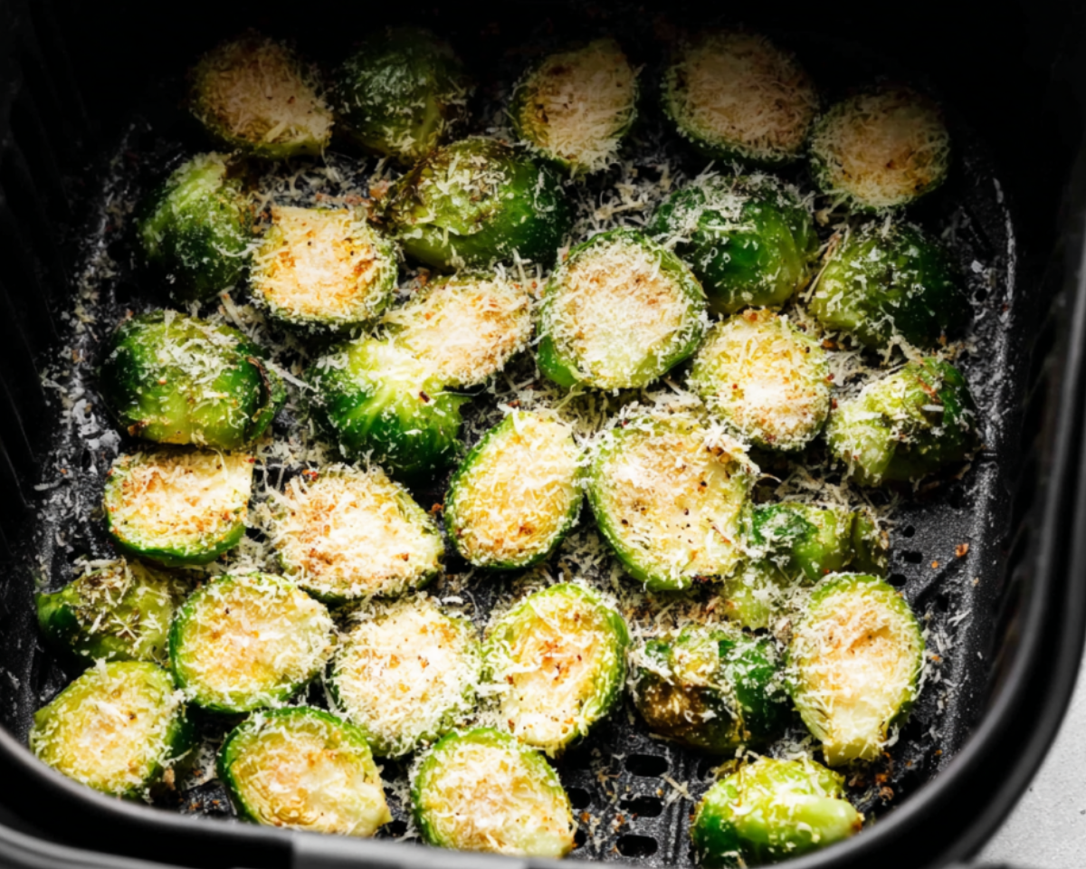 brussels sprouts in air fryer basket with parmesan