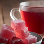 Pink gelatin cubes with warm drink